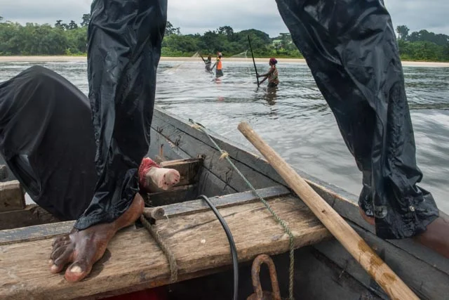Jean, age 24 goes with his mom to catch the shrimps that will be they bay for their fishing day.