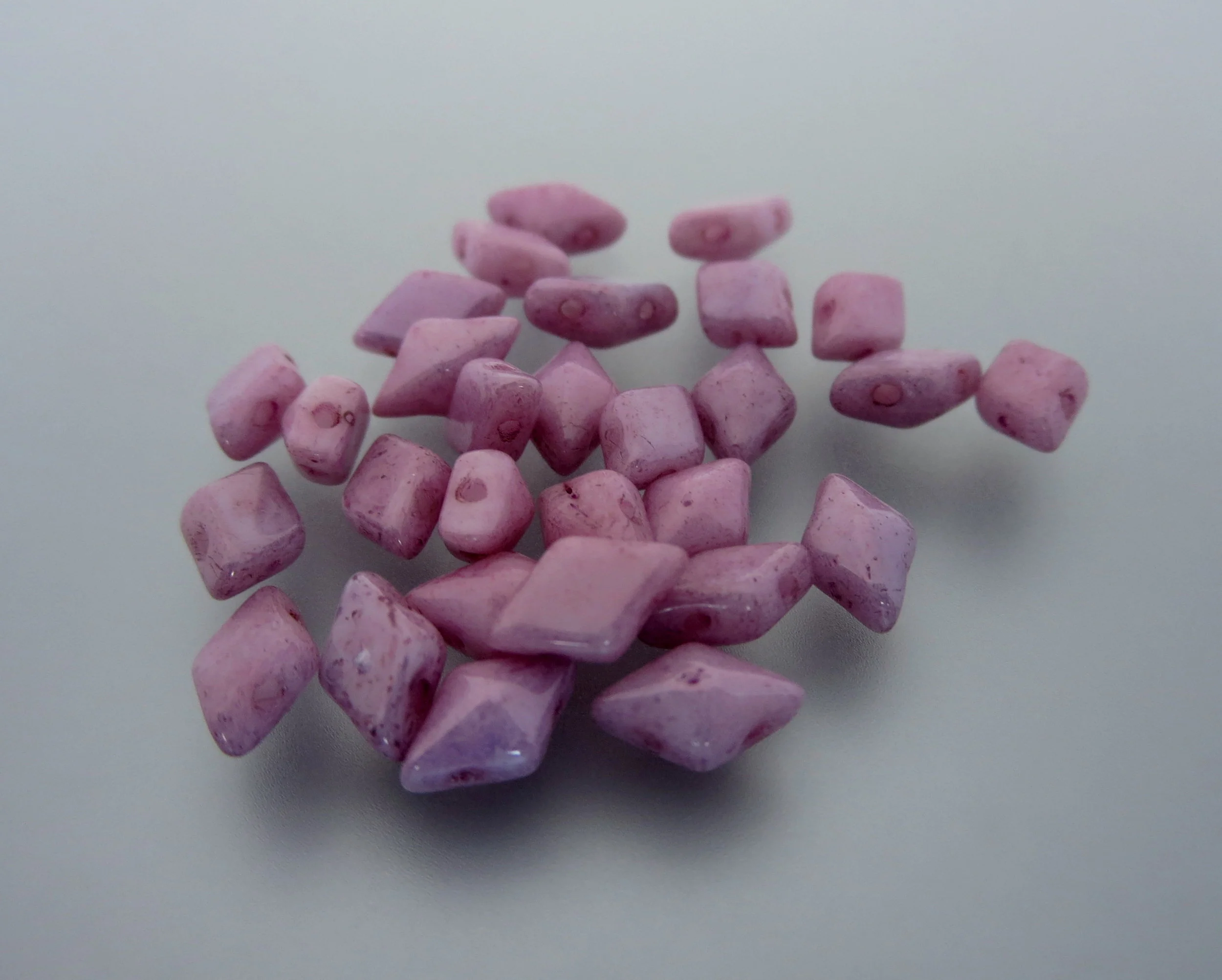 The Buffalo Bead Gallery sells DiamonDuos are a 2-hole Czech pressed glass bead made in the Czech Republic. The diamond shape bead measures 5x8mm (5mm in width and 8mm in length), with a 1mm hole.