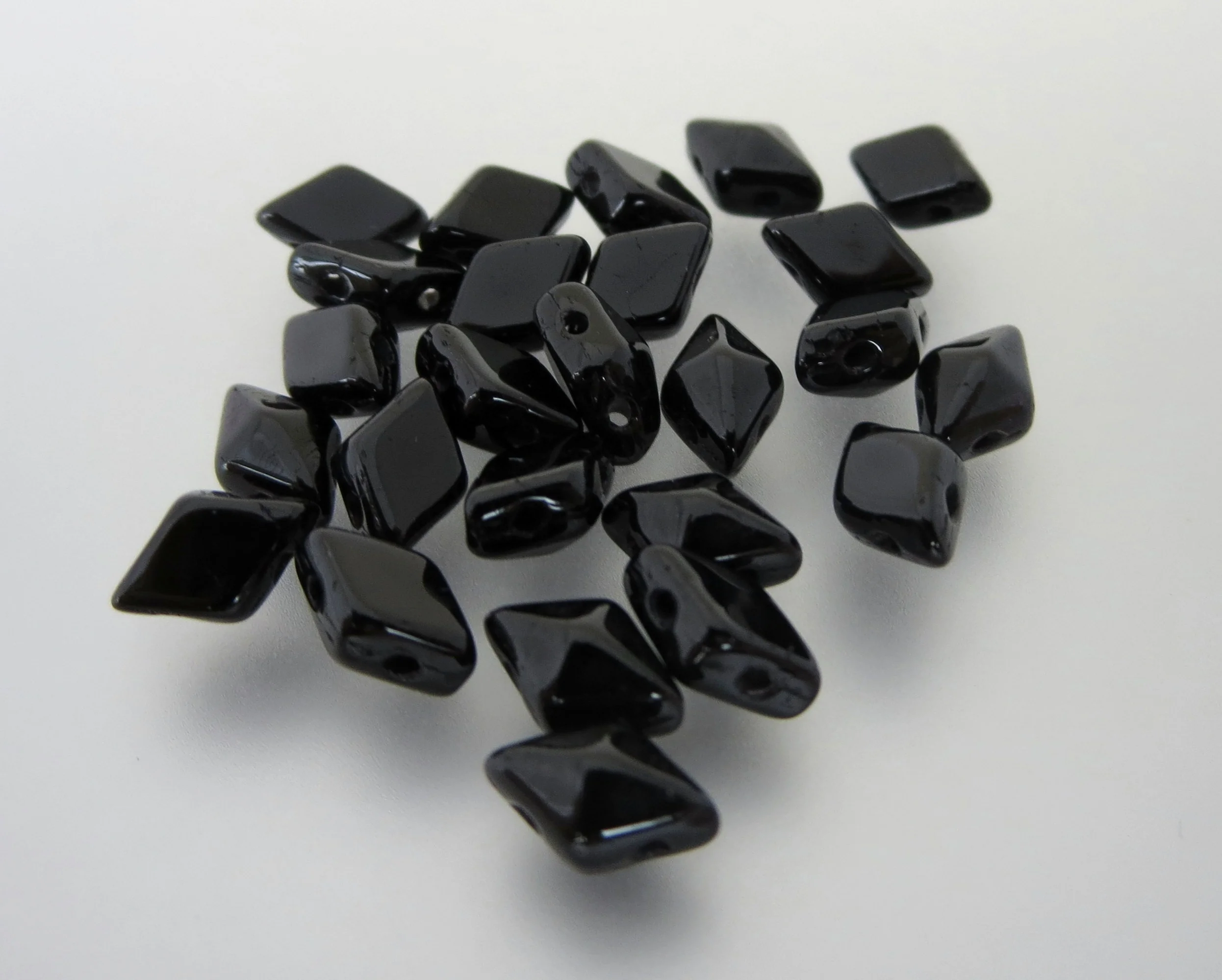 The Buffalo Bead Gallery sells DiamonDuos are a 2-hole Czech pressed glass bead made in the Czech Republic. The diamond shape bead measures 5x8mm (5mm in width and 8mm in length), with a 1mm hole.