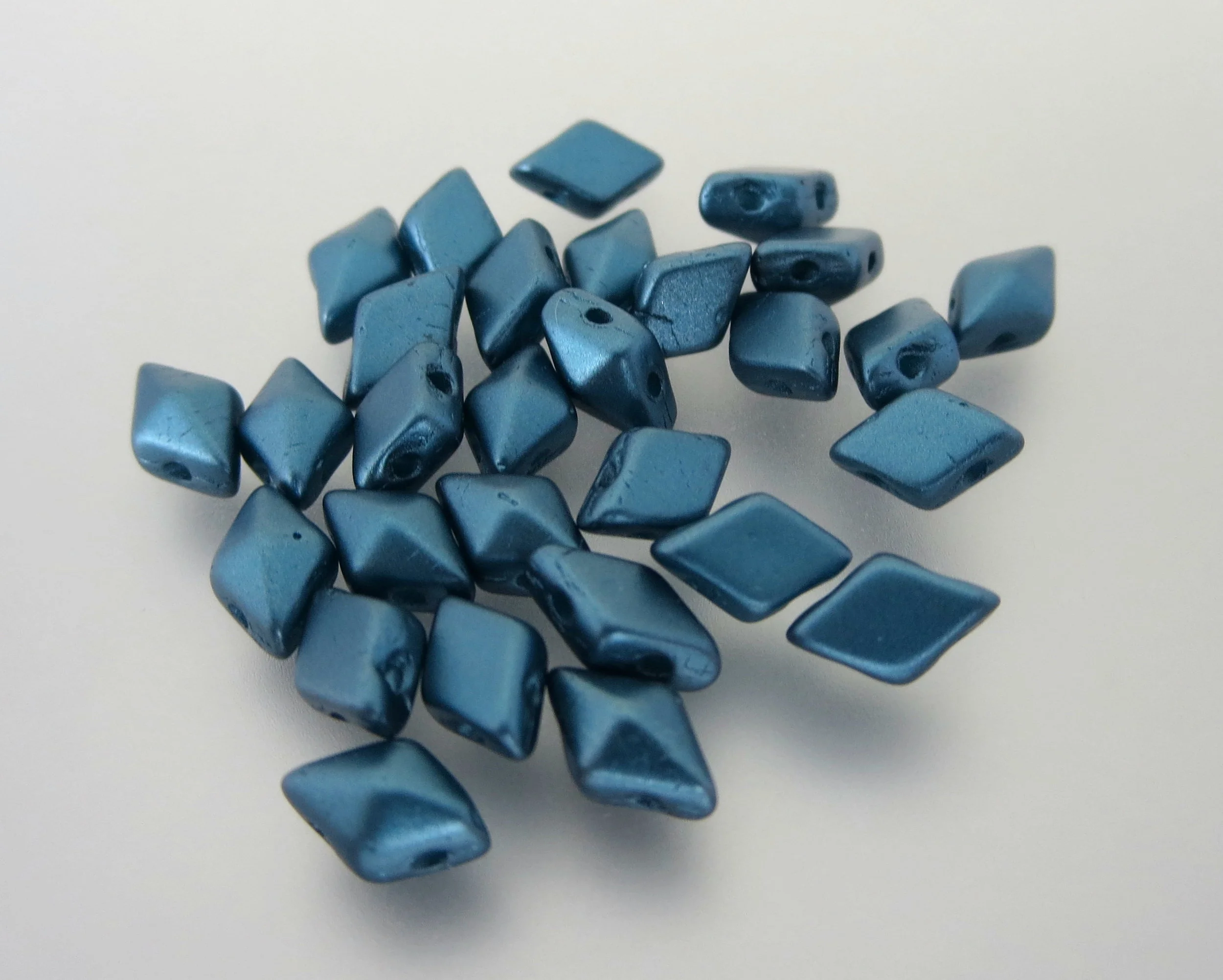 The Buffalo Bead Gallery sells DiamonDuos are a 2-hole Czech pressed glass bead made in the Czech Republic. The diamond shape bead measures 5x8mm (5mm in width and 8mm in length), with a 1mm hole.