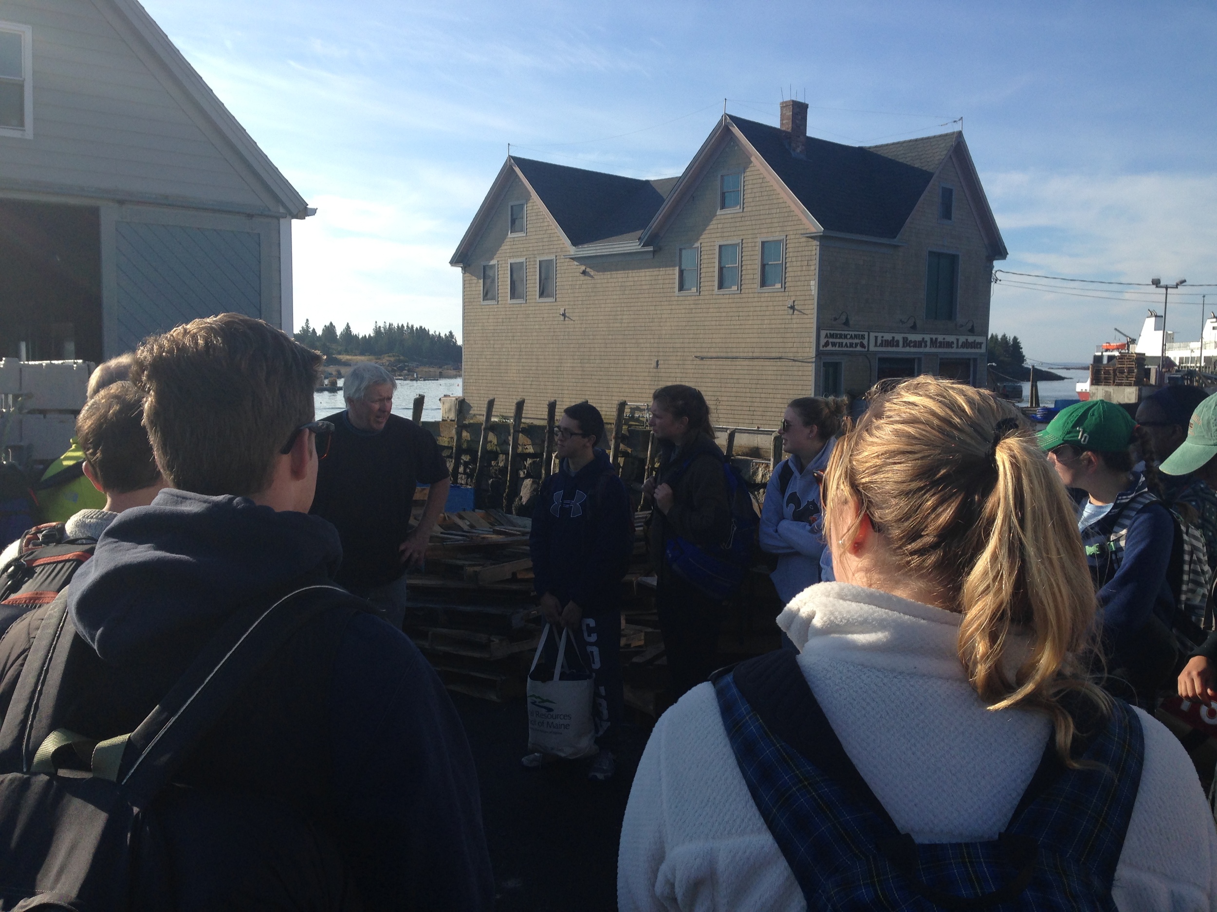Colby students gather outside the Vinalhaven Co-op to learn more about the operation and the fishery from Mike Mesko. 