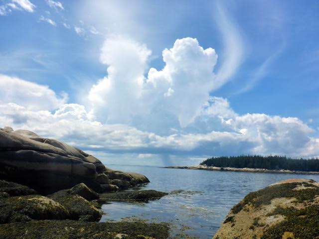 On a sunny day, the cumulus clouds are piling up, with a cirrus cloud known as a horsetail in the background.