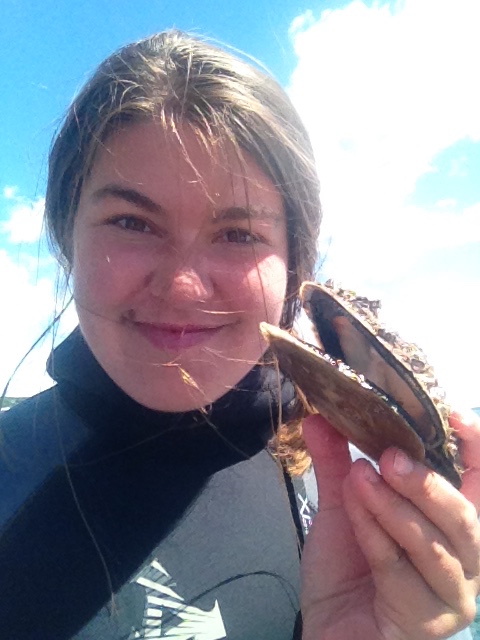 Research Assistant Bailey Moritz posing with a scallop