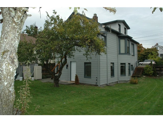   Looking at the triplex from the west end of the back yard. Occupied unit is the middle unit on the right of this picture, right side of the main floor only. Basement unit is through the white door in the picture.  