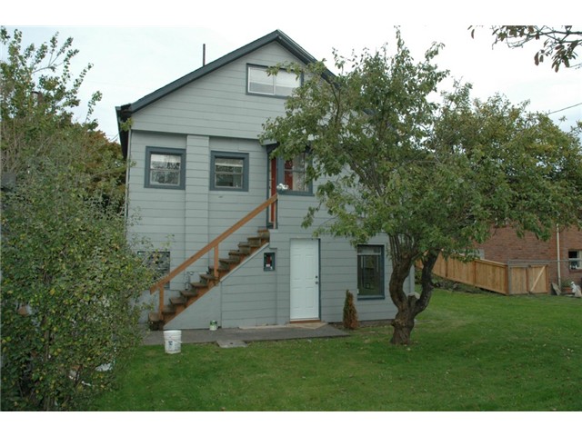   Another view of the back of the triplex. Lower unit access is thru the white door. Access to the second unit is up the stairs, the red door. Main floor unit is townhouse style with two bedrooms on the upper floor.  