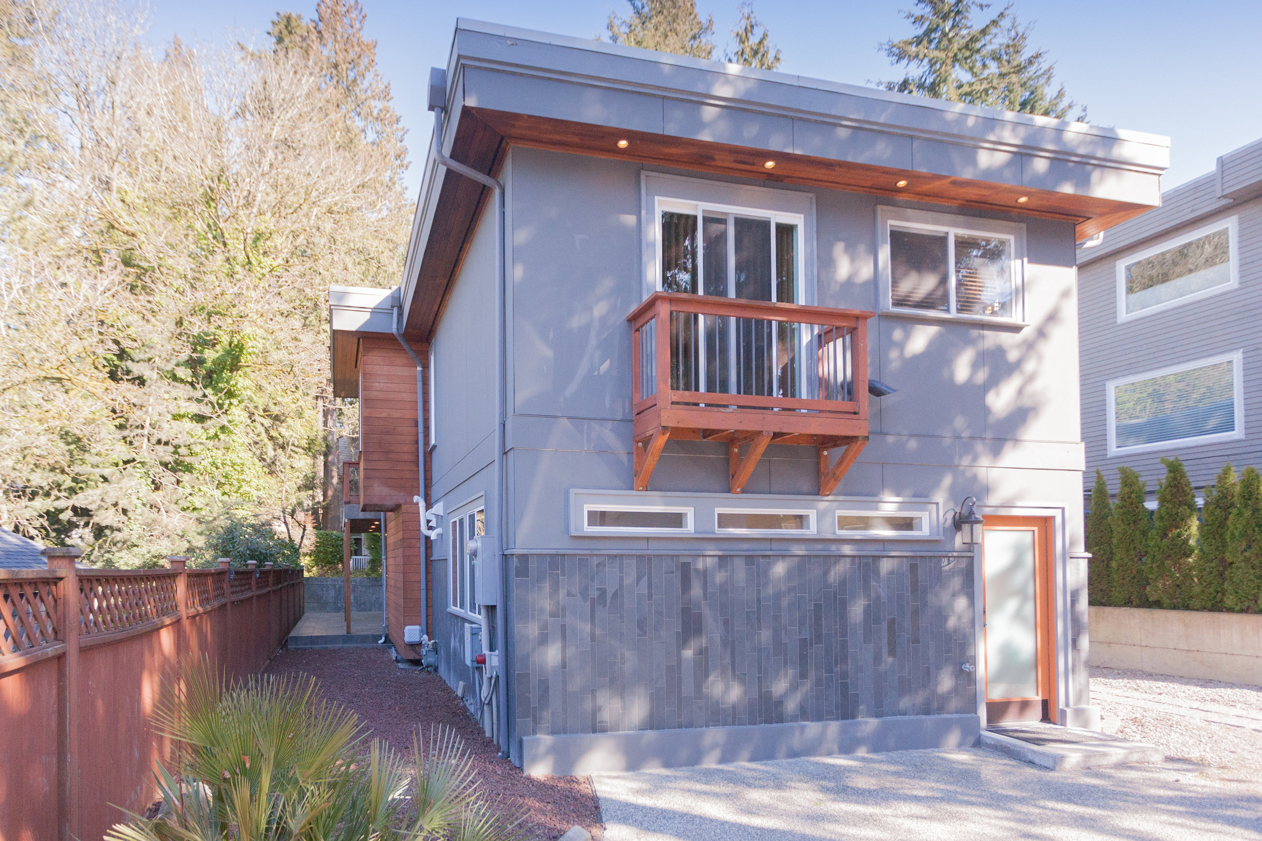  From driveway. One of two entry doors to the main floor (this one is  nearest the third bedroom, making it convenient and private for  house-guests). The balcony pictured is off the second master. 