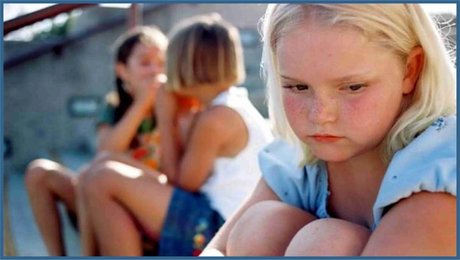 School girl sitting looking sad in the playground