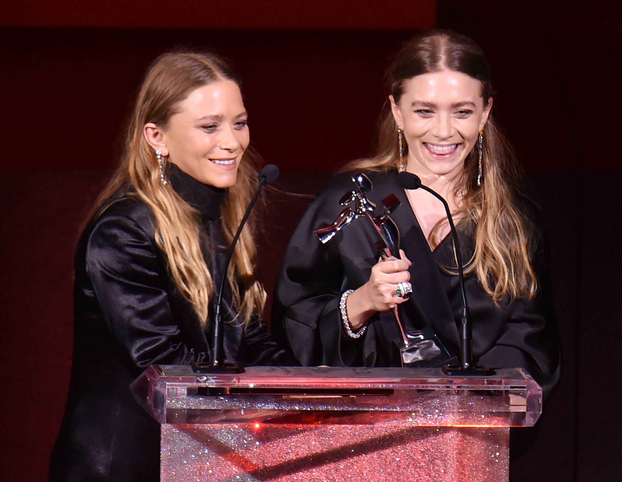 Mary Kate and Ashley Olsen accepting their award for Womenswear Designer(s) of the Year for their line The Row. The twin duo also won for womenswear in 2012 and accessories in 2014. image via Bustle.com