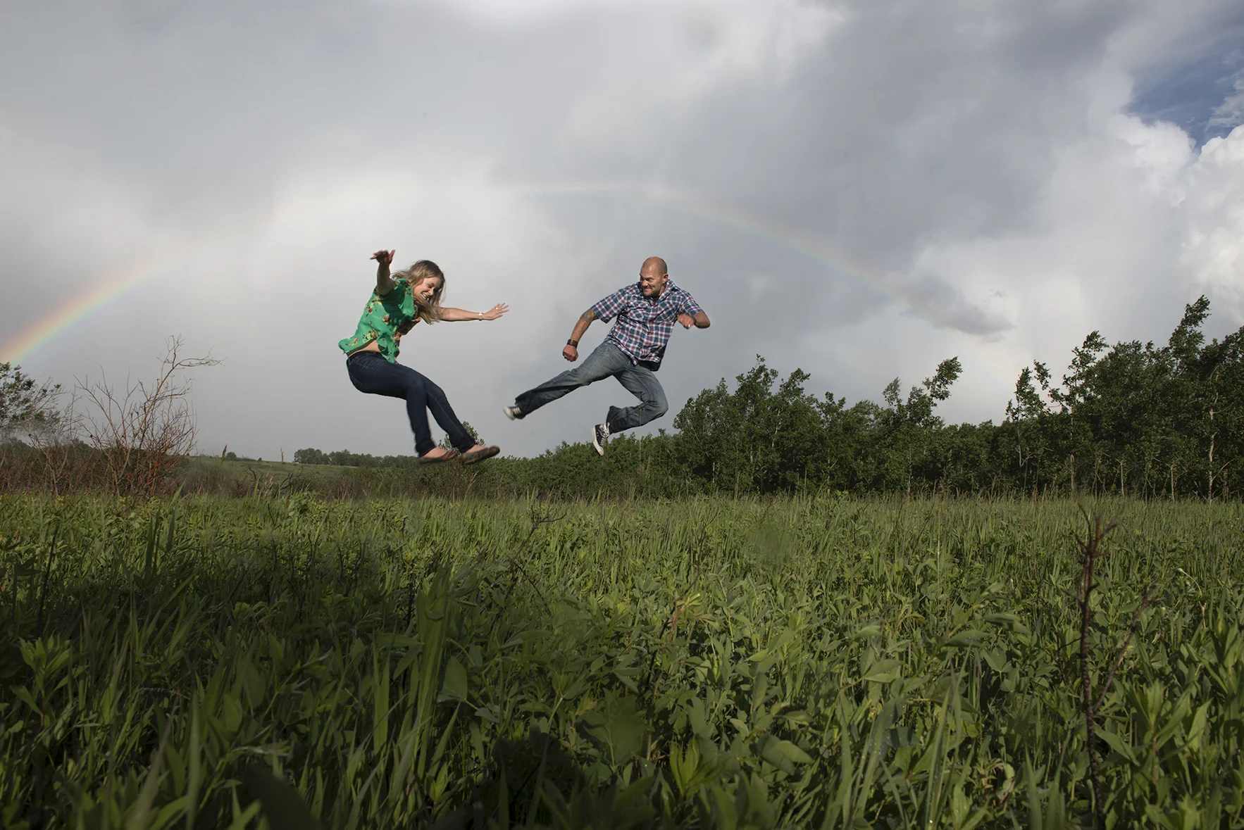 Calgary Wedding Photographer Photos By Adele has captured a beautiful portrait of a couple with a rainbow at Nose Hill Park, Calgary Alberta.