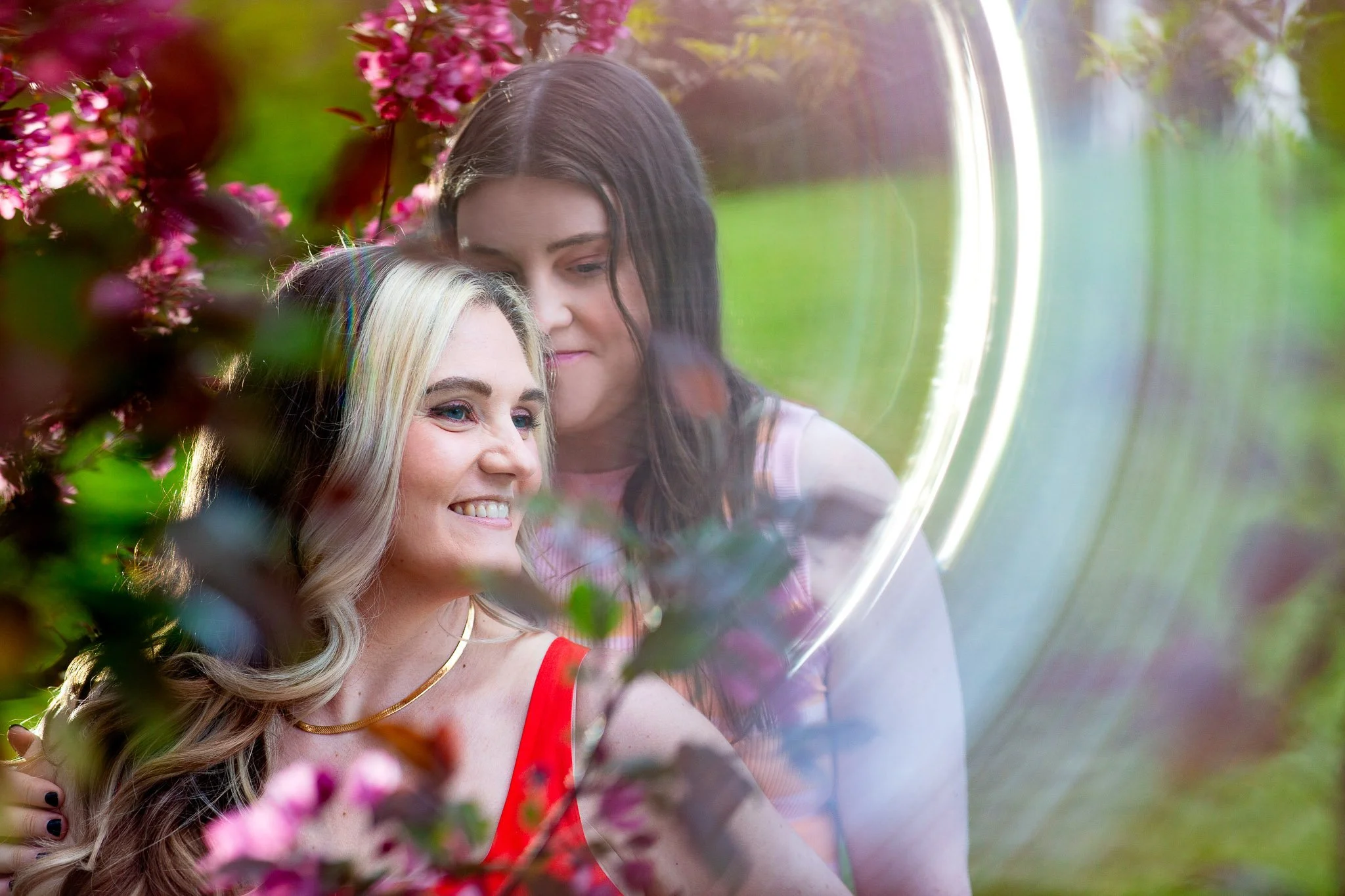Happy couple celebrating their engagement in a vibrant spring setting at Baker Park in Calgary.