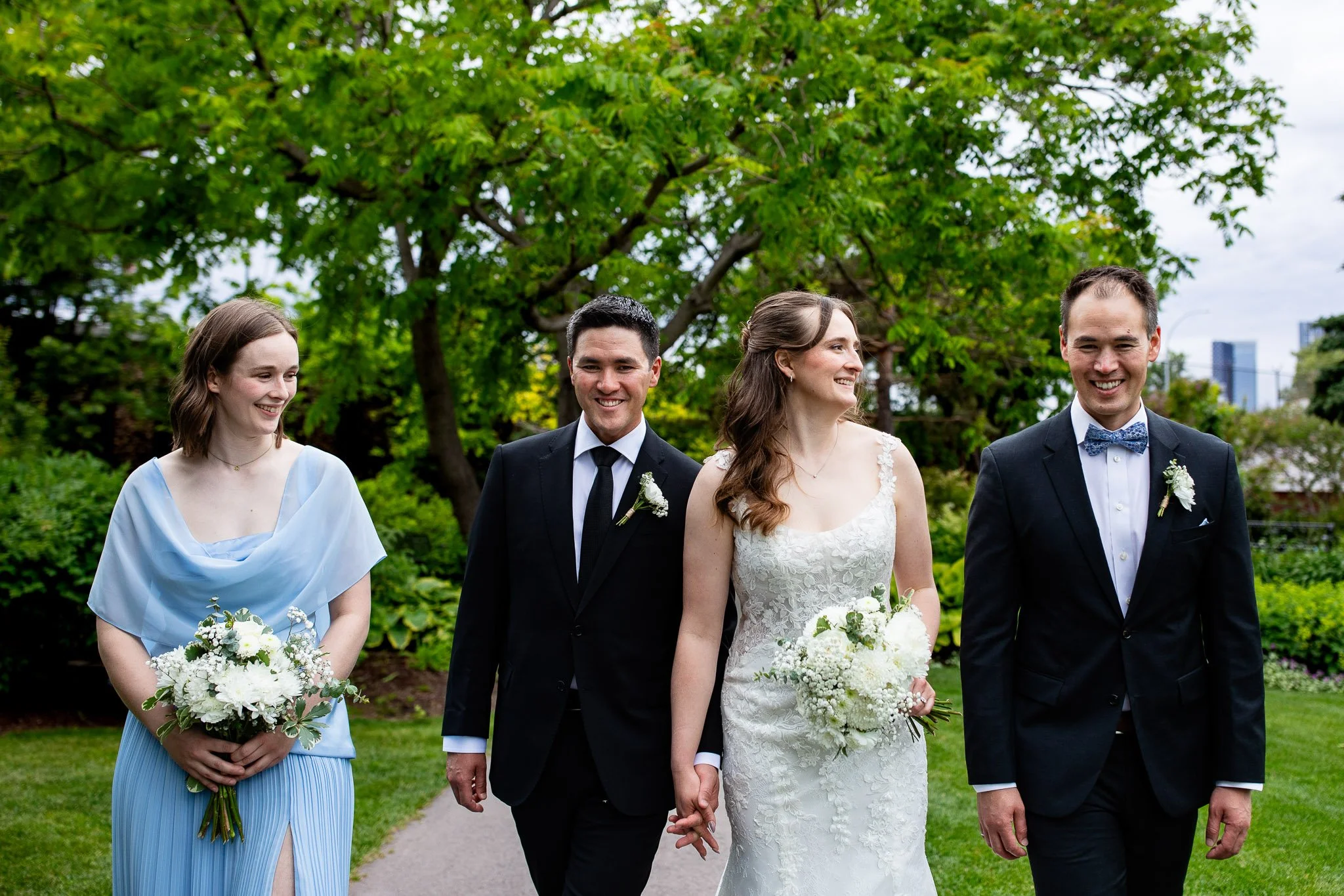 Bridal party celebrating together in the gardens at the Calgary Zoo wedding venue.