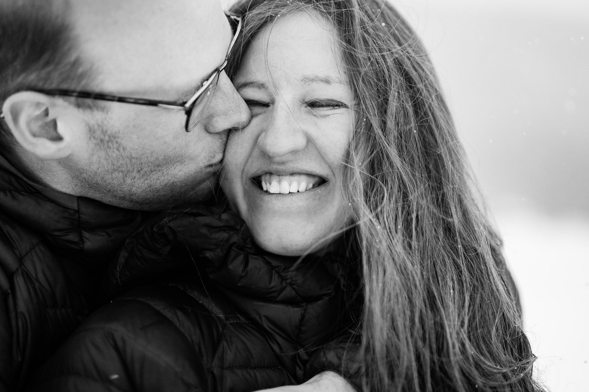Adventure-loving couple exploring the snowy foothills near Kananaskis during their engagement photo session.