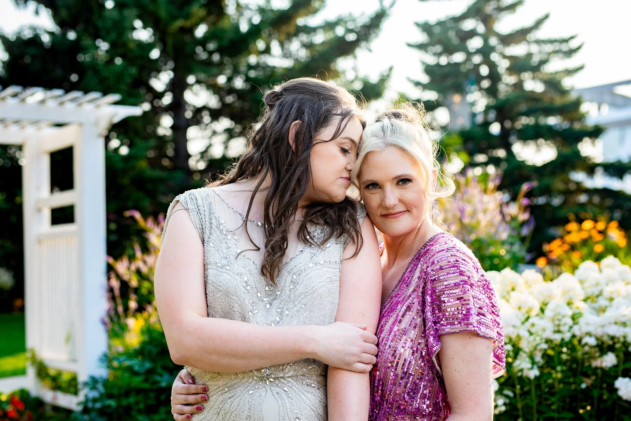 couple cuddle together in vibrant Deane House garden venue.