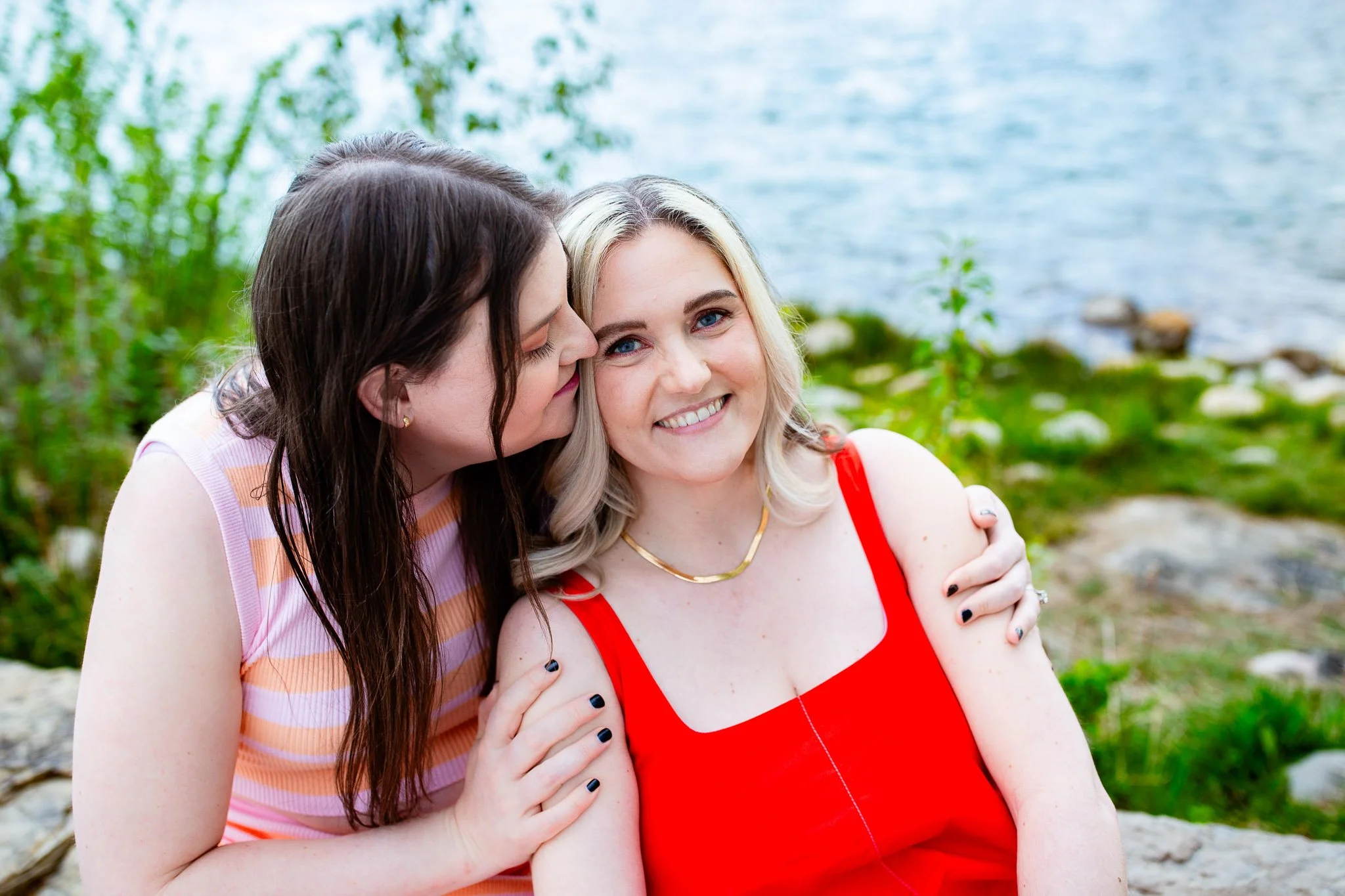 Dianna and Annika enjoying a quiet moment beside the Bow River during their engagement photo session.