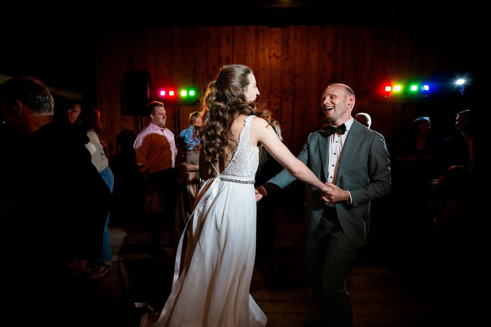 Couple dancing on a packed dance floor at a rustic lodge wedding reception outside Calgary