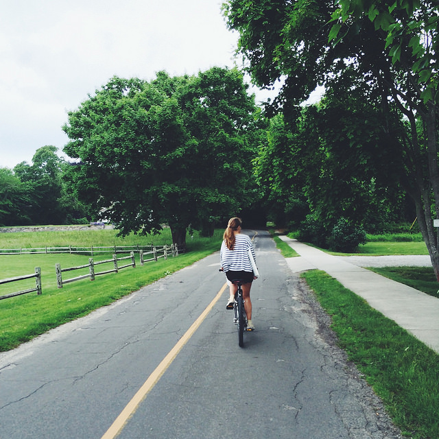 Jane biking home with her rummage sale treasure--a floral serving tray from the 1960s she scored for a buck.