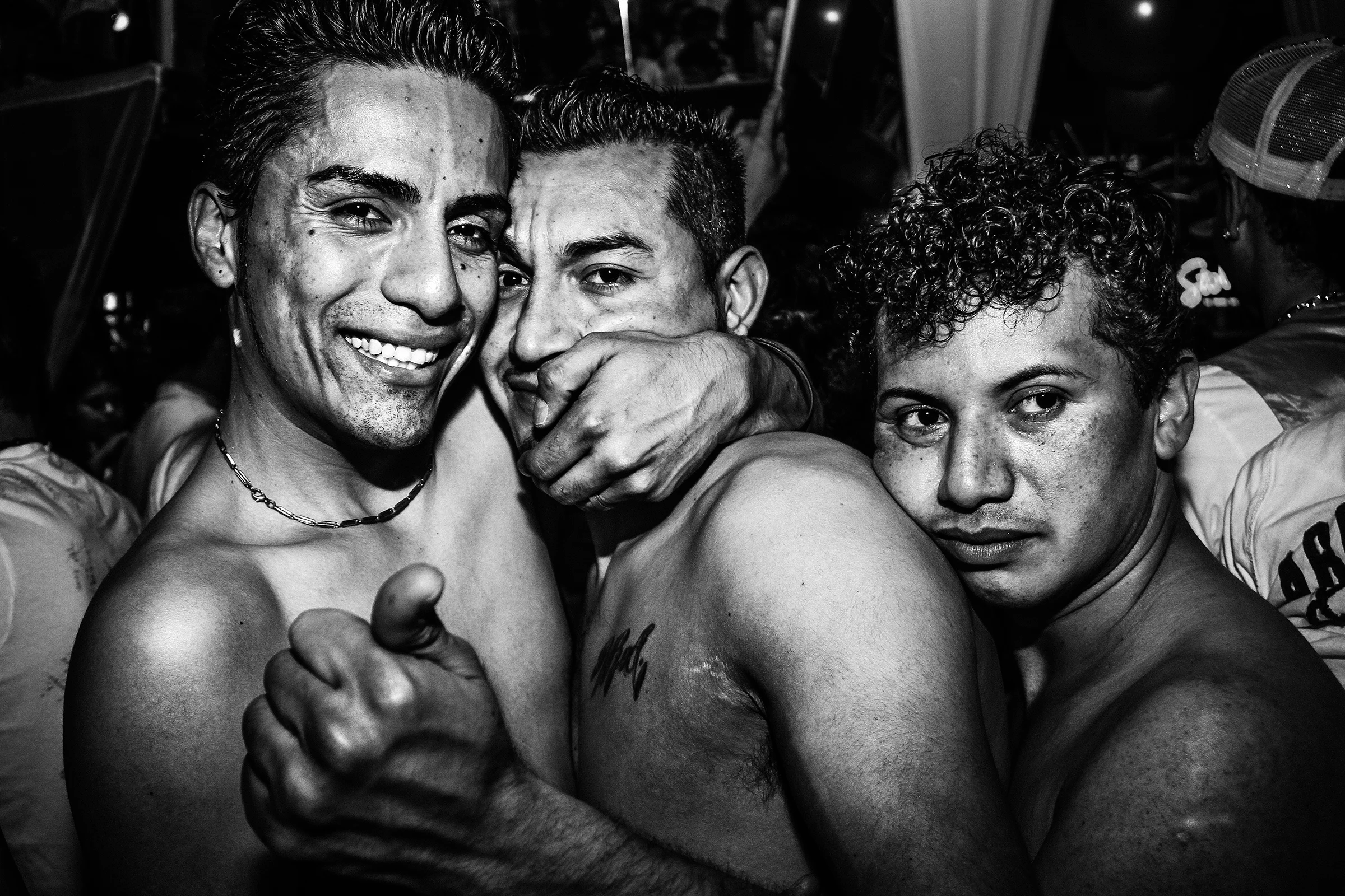 Three men embrace at Entre Hermano's annual Latin White Party at Neighbours Nightclub on April 17th, 2011, in Seattle.