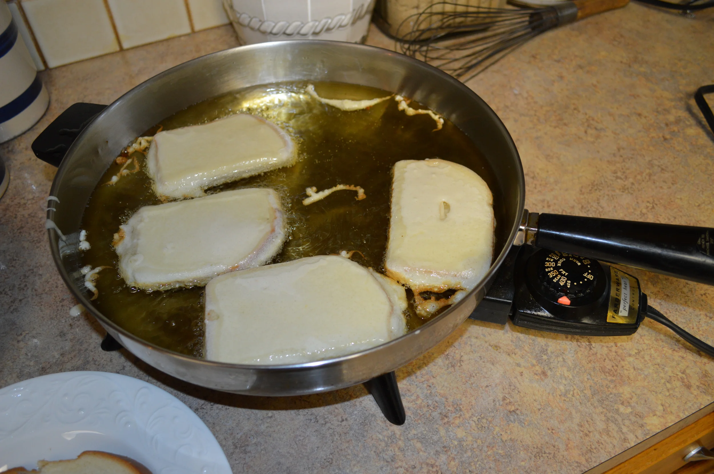 Bread dipped in batter and placed in hot oil..
