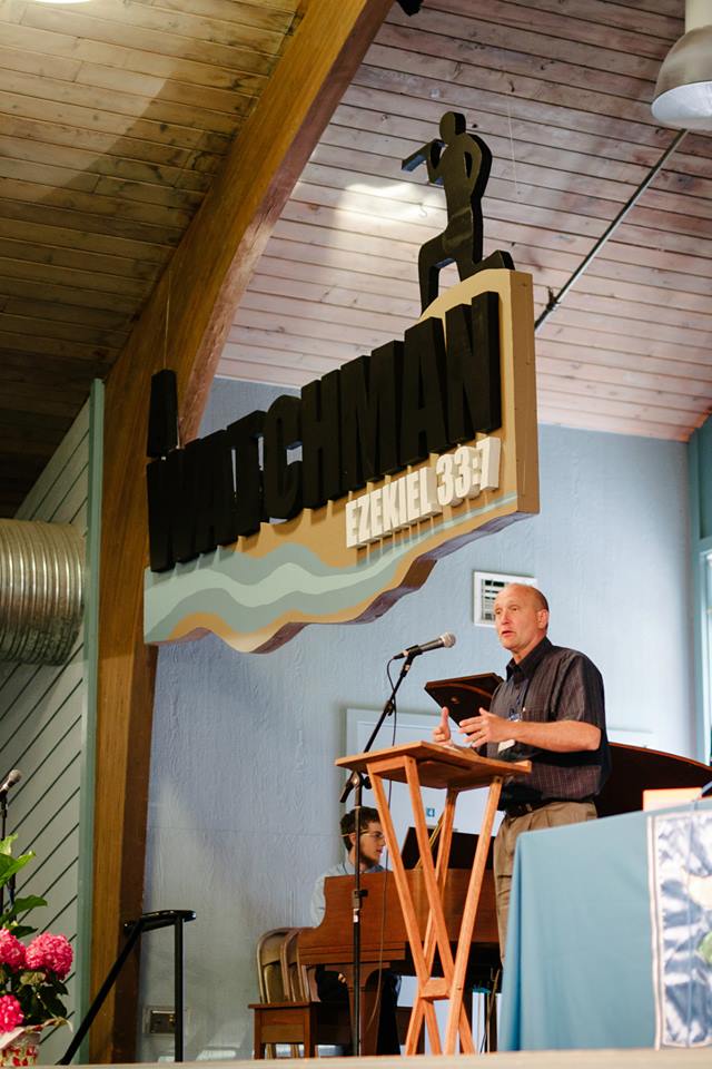 Pastor Mark's artistic banner...(with Pastor Steve Snipstead speaking, photo by Ruth Gunderson).