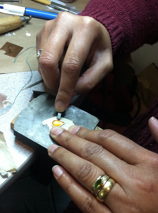  Stone setting! Here I use a bezel pusher, basically a short, square, steel rod to push&nbsp; the top of the bezel over the curve of the stone. I’ve covered my earring with masking tape to protect the piece from deep, soul-crushing scratches that the