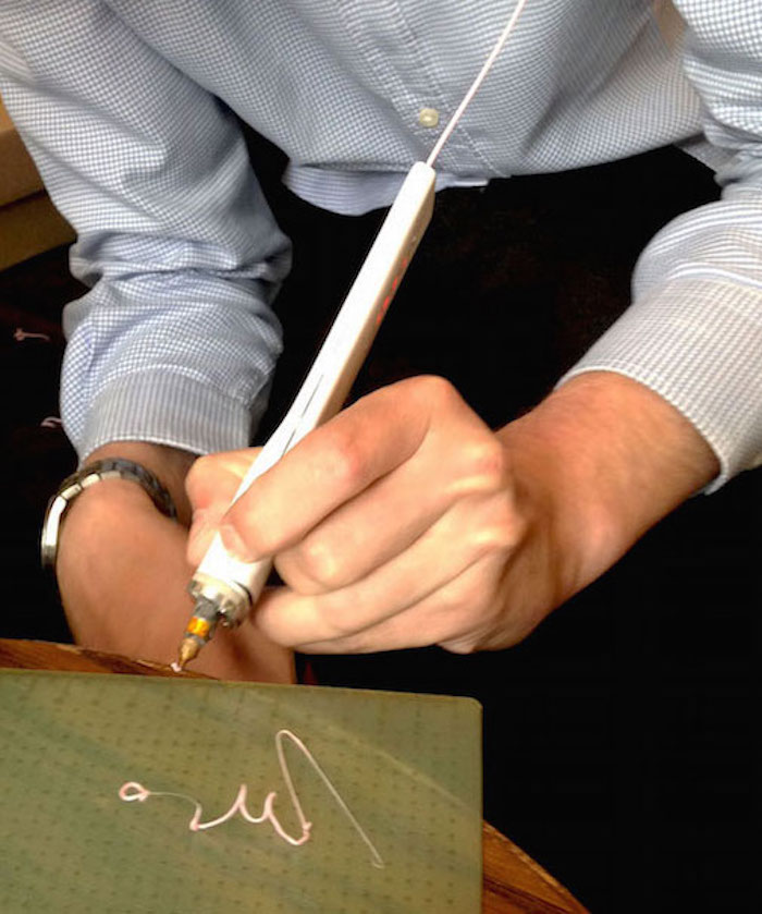 3D Simo CEO David Paskevic feeds plastic into a prototype of his new 3D mini pen. Image Courtesy: Hilary Brueck