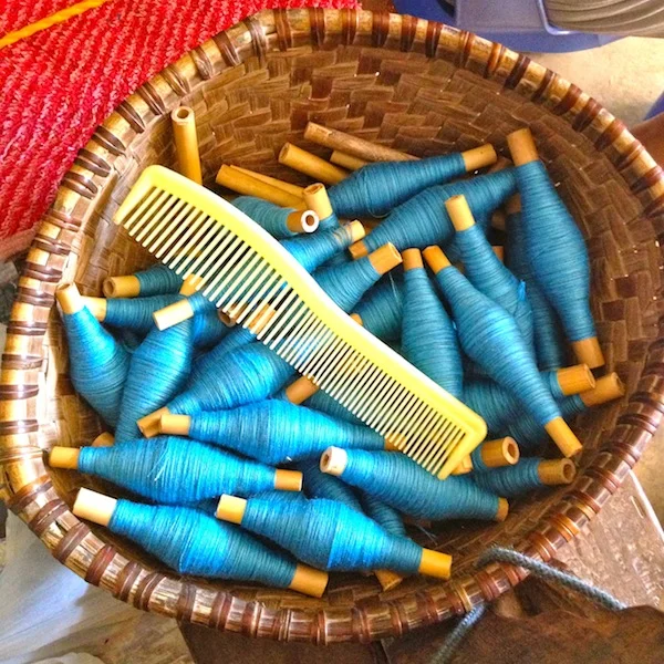 Basket full of spun yarn for the weft.