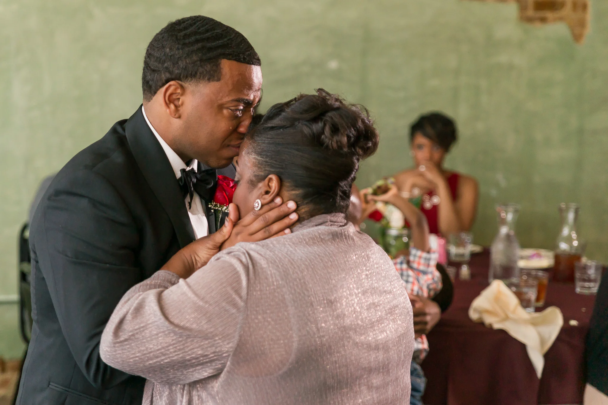 Emotional groom and mother at reception