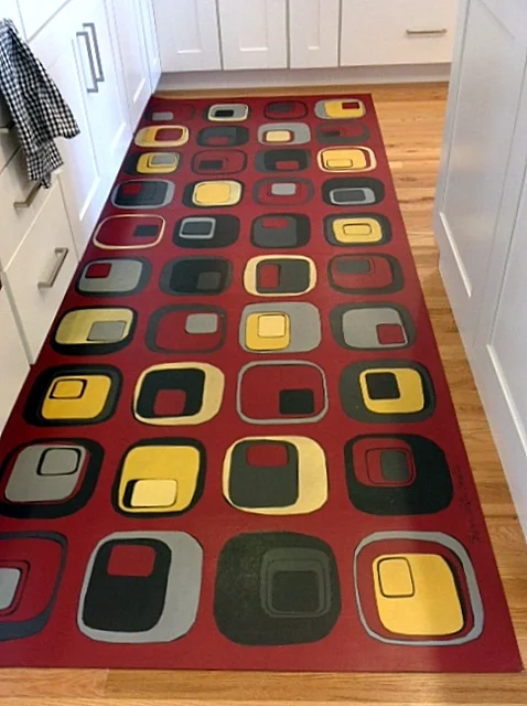 Custom rug for galley kitchen designed to coordinate with upholstery fabric.