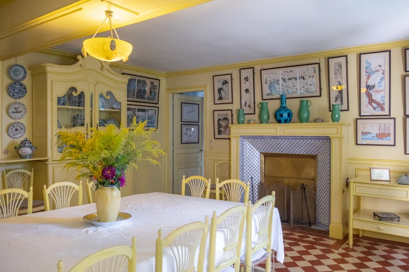 Look at the colors of those vases over the fireplace. The floor is an amazing design as is the color that was chosen. And it all goes together. Not only does he love color, he loves decorating. This room gives me a sense of happy times with lots of great meals and family and friend. Simple but inviting.