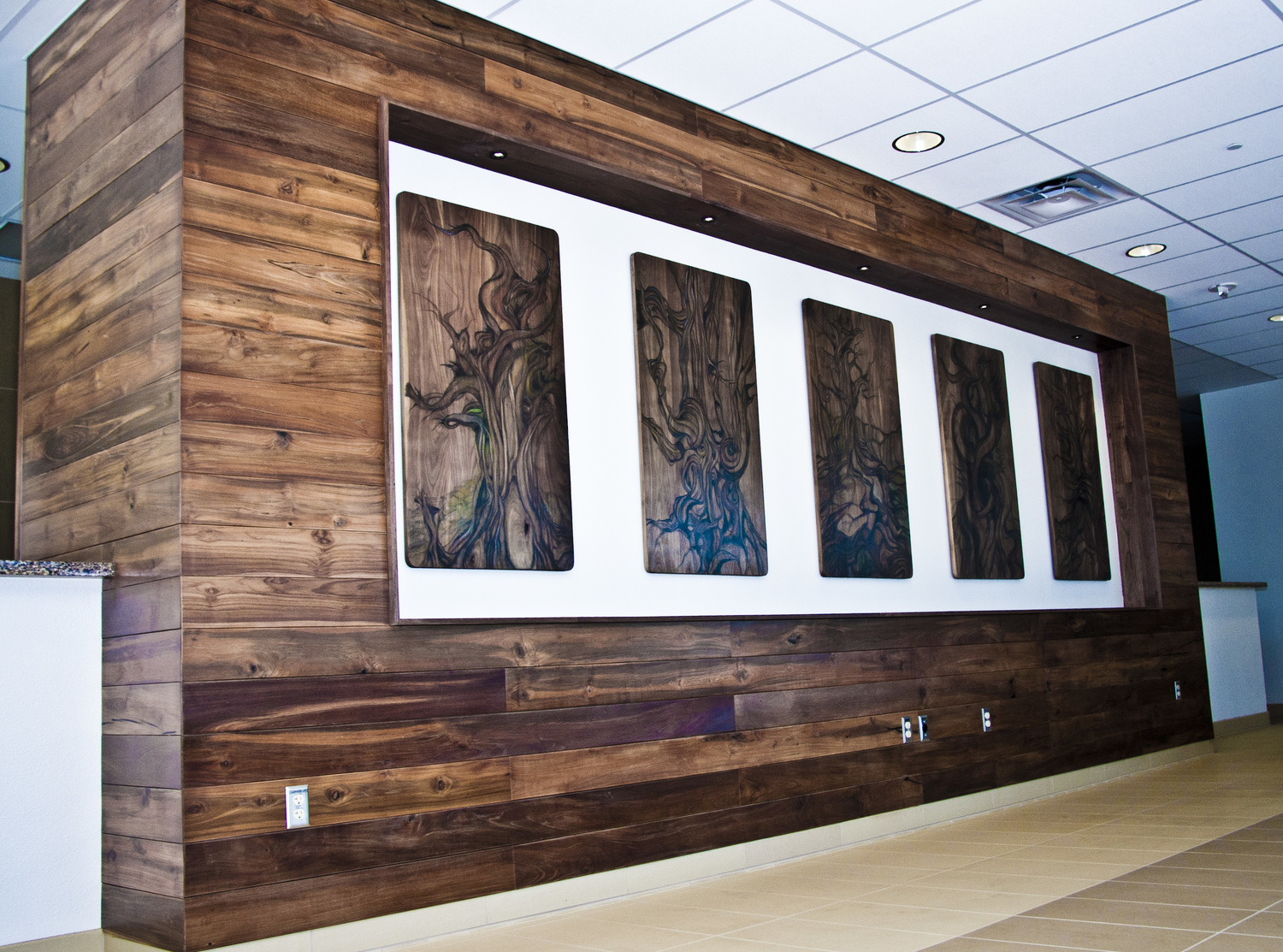 theANCIENTS | Las Vegas City Hall | Las Vegas, NV (2012) I was commissioned to create two large scale public art projects for the New Las Vegas City Hall. The first piece is bristles...; a triptych painting showcasing the bristlecone pine tree in a loose and playful style. He used solid spalted maple boards as the canvas along with inlayed Nevada turquoise, watercolor, colored pencils, acrylic, and graphite. They are framed with custom floating gunmetal steel frames at the front lobby. theANCIENTS is located in the second floor event space and is a series of five paintings depicting iconic bristlecone pine trees These pieces are painted on solid walnut and housed in a custom art wall. The art wall is cladded in FSC reclaimed teak and walnut. 