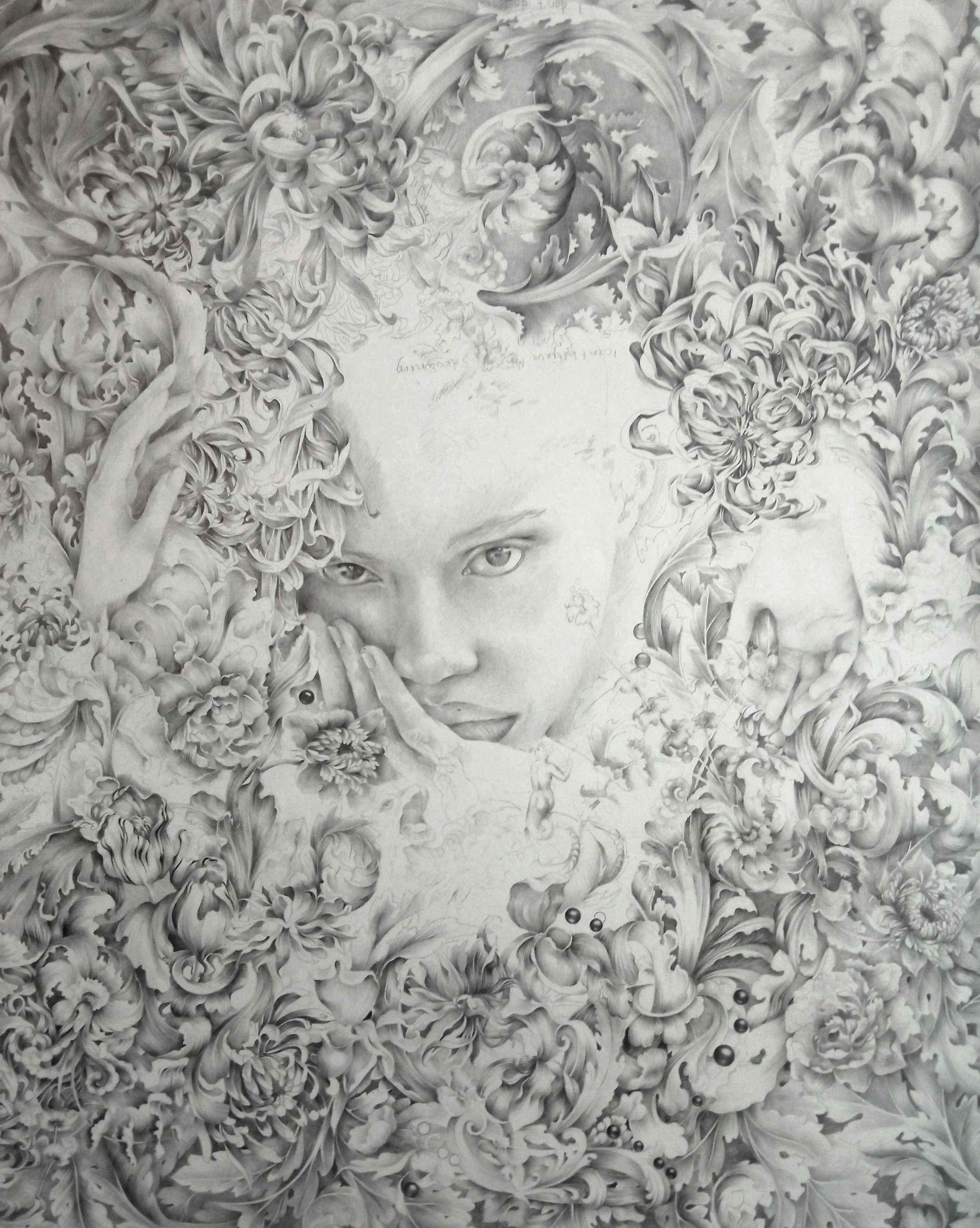 Black and white pencil drawing of a woman's face surrounded by detailed floral patterns, with her hand partially covering her mouth and intense gaze.