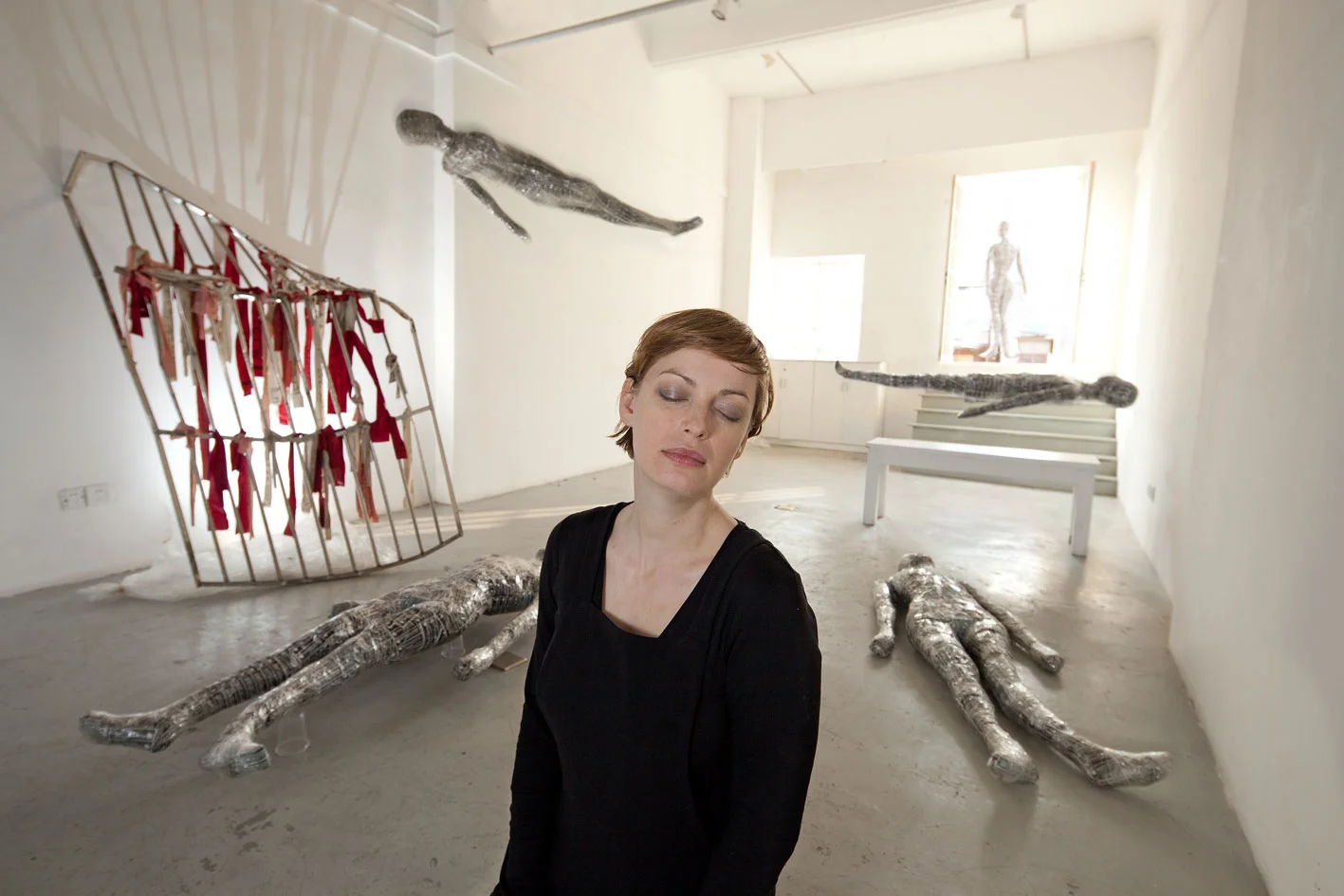 Susanne Junker photographed by Eric Leleu at stage候台BACK 696 with floating self dolls , shortly before the eviction of artists, 2011