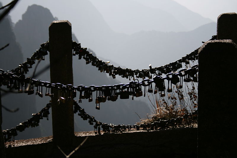 Nearly every metal chain-link fence or metal pole in Mount Huang , China has been adorned with padlocks, where it is customary to 'lock your soul' together and then throw the key over the edge of the cliff into the misty valleys below. This may be where the tradition originated.