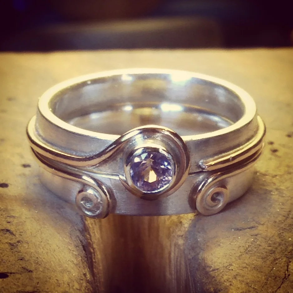 Silver and gold wedding and engagement rings, set with a fair trade pink spinel.