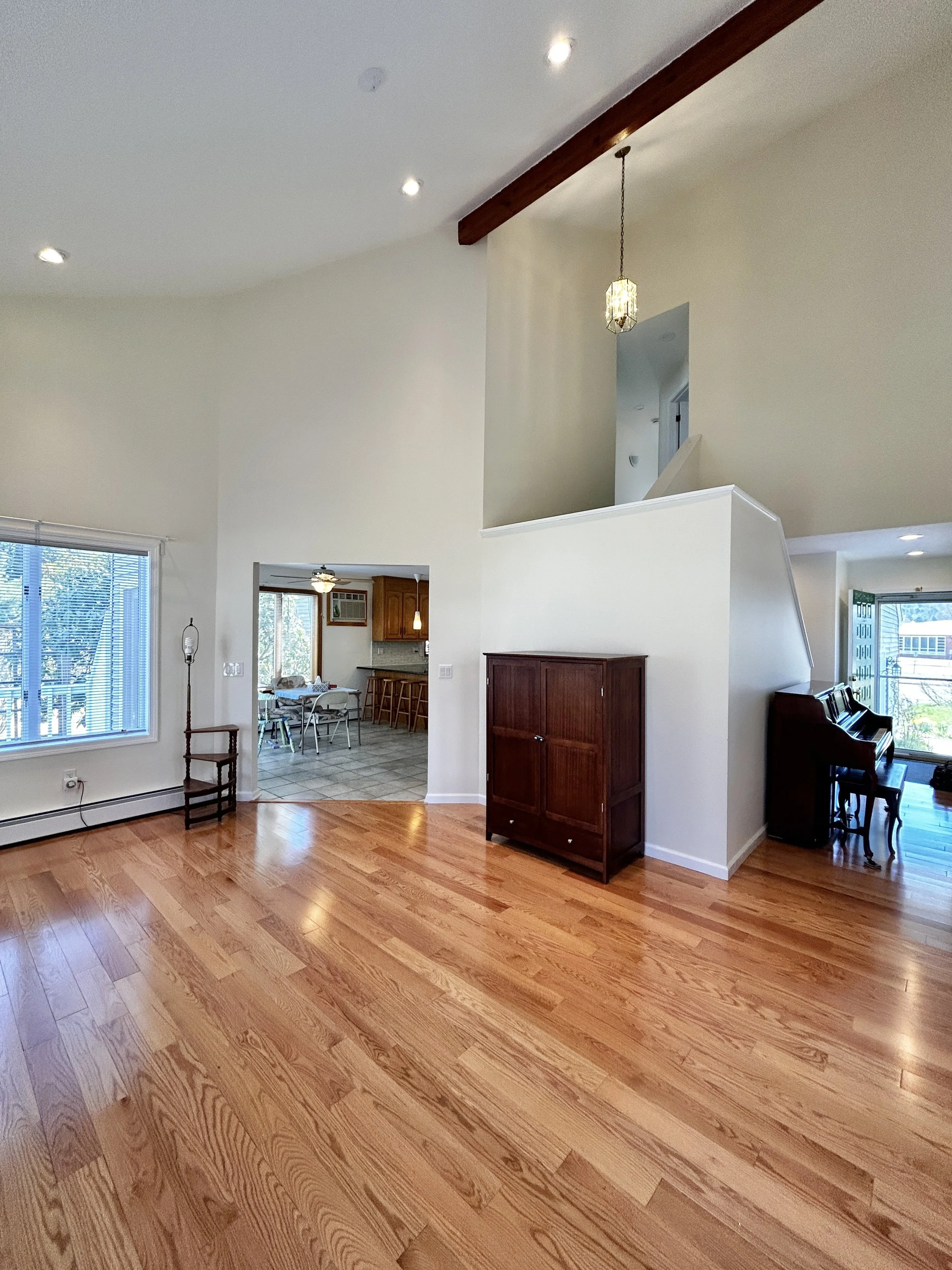 Living area with entryway to the right and dining area to the left.