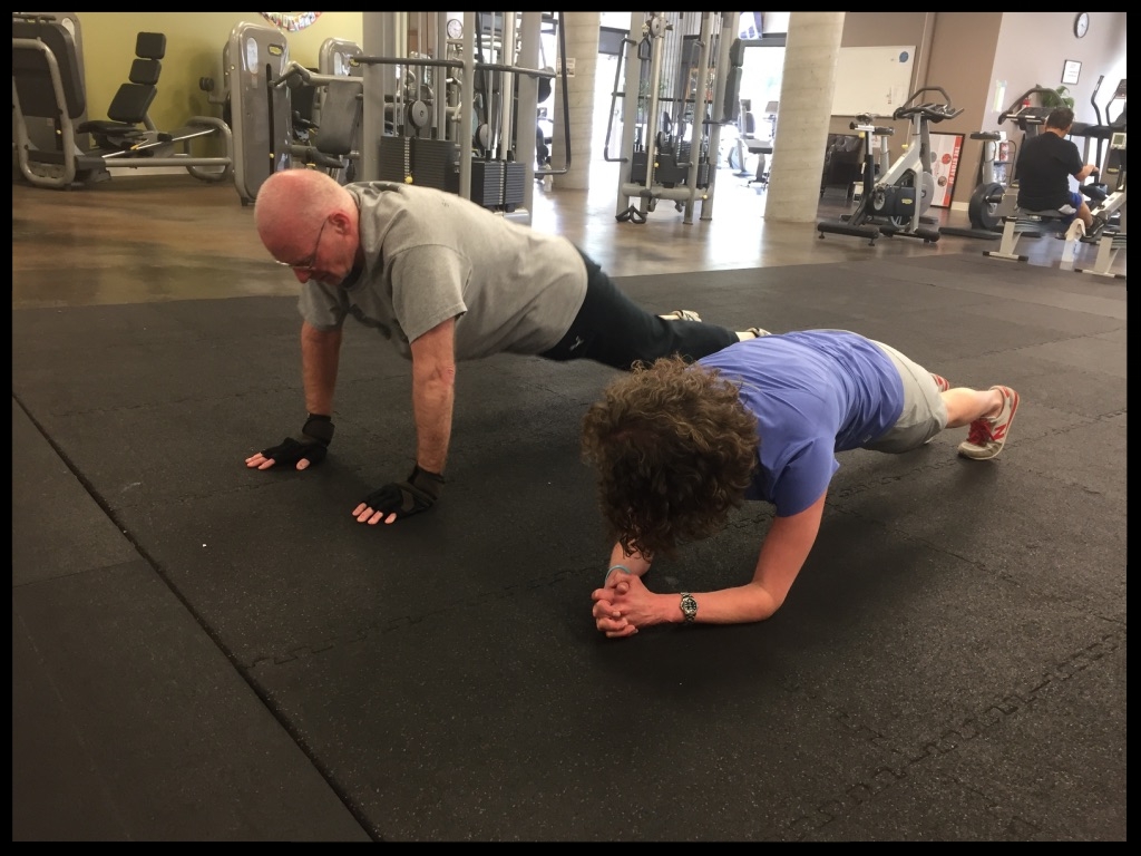 Rachel holds a plank while Leo does push-ups