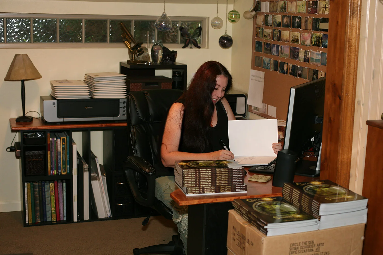 Susan happily signing and shipping books!
