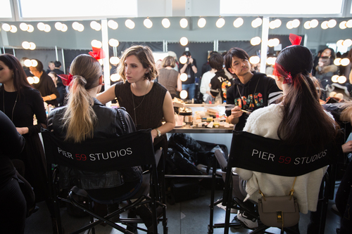 It takes an army. Beauty teams work backstage to get models runway-ready.