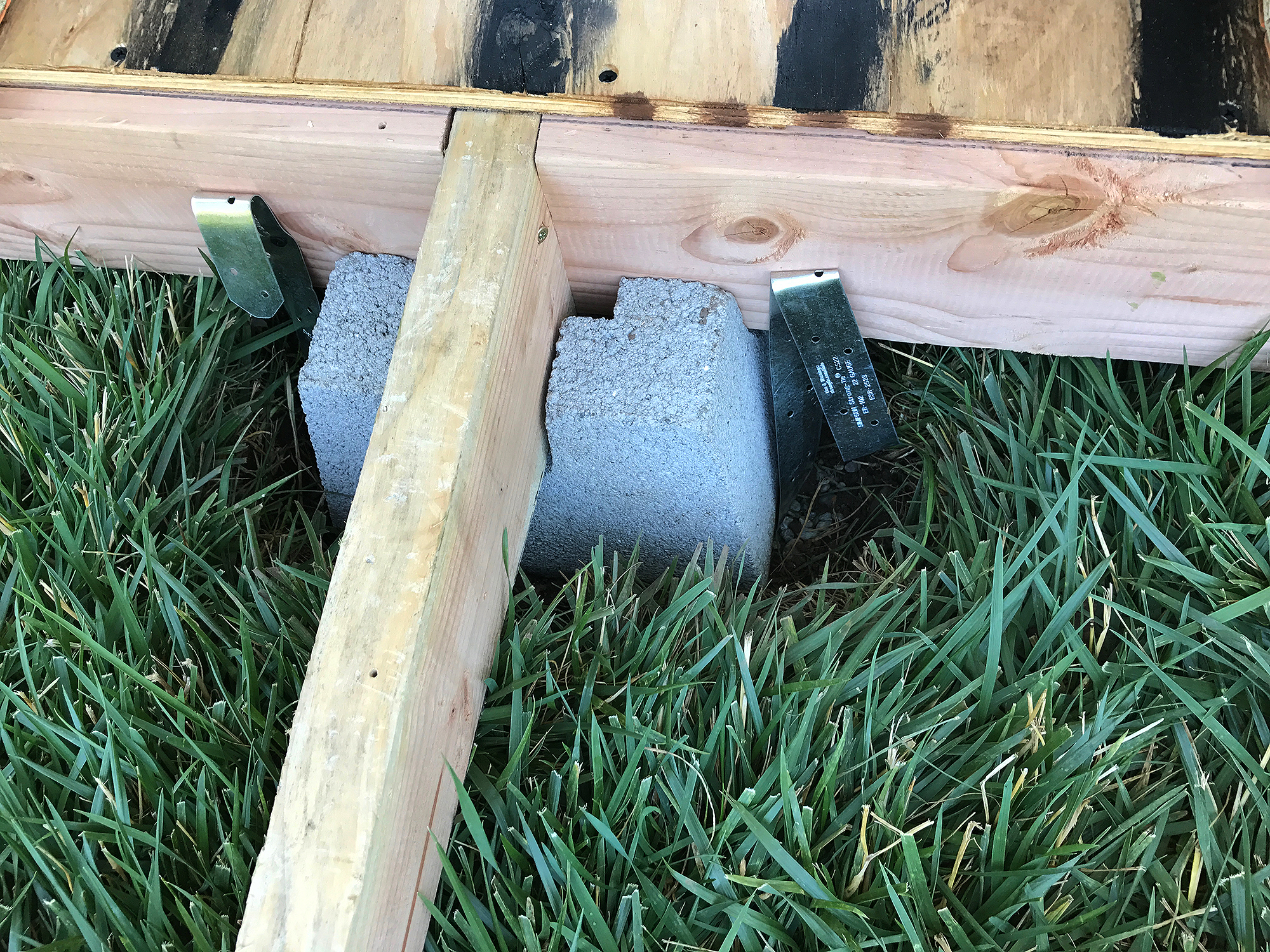 blocks are sunken into the lawn to support the frame