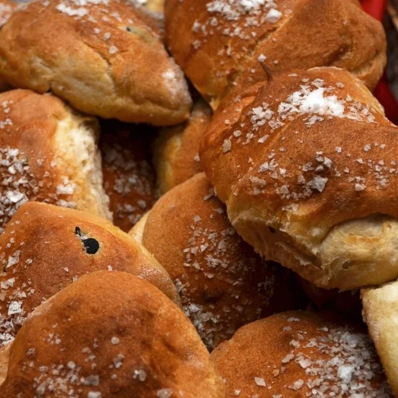 OLIVEN Vi vil påstå at dette er verdens beste olivenrundstykker! Store flotte rundstykker - ferske hver eneste dag! Hvetemel, salt, gjær, vann, oliven, rosmarin, olivenolje. Helt rundstykke 29,- Påsmurt halvt rundstykke 35,- (ta med 32,-) Inneholder: hvete, bygg