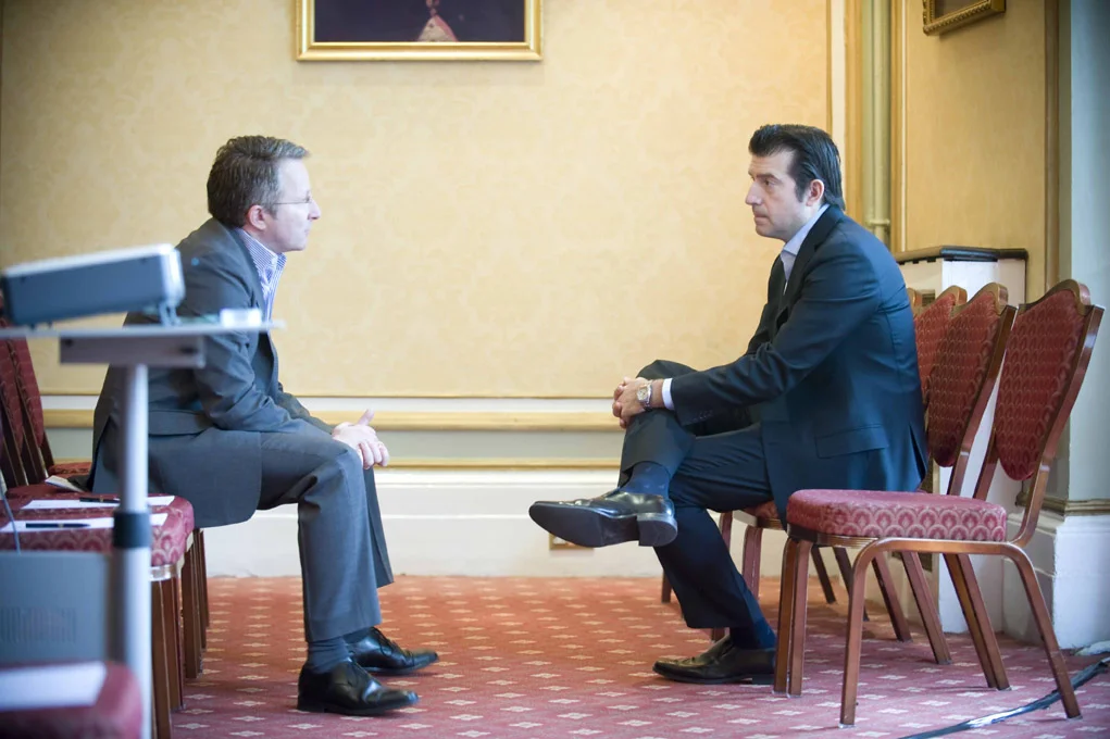 Candid Conference Portrait of two businessmen in suits sitting talking