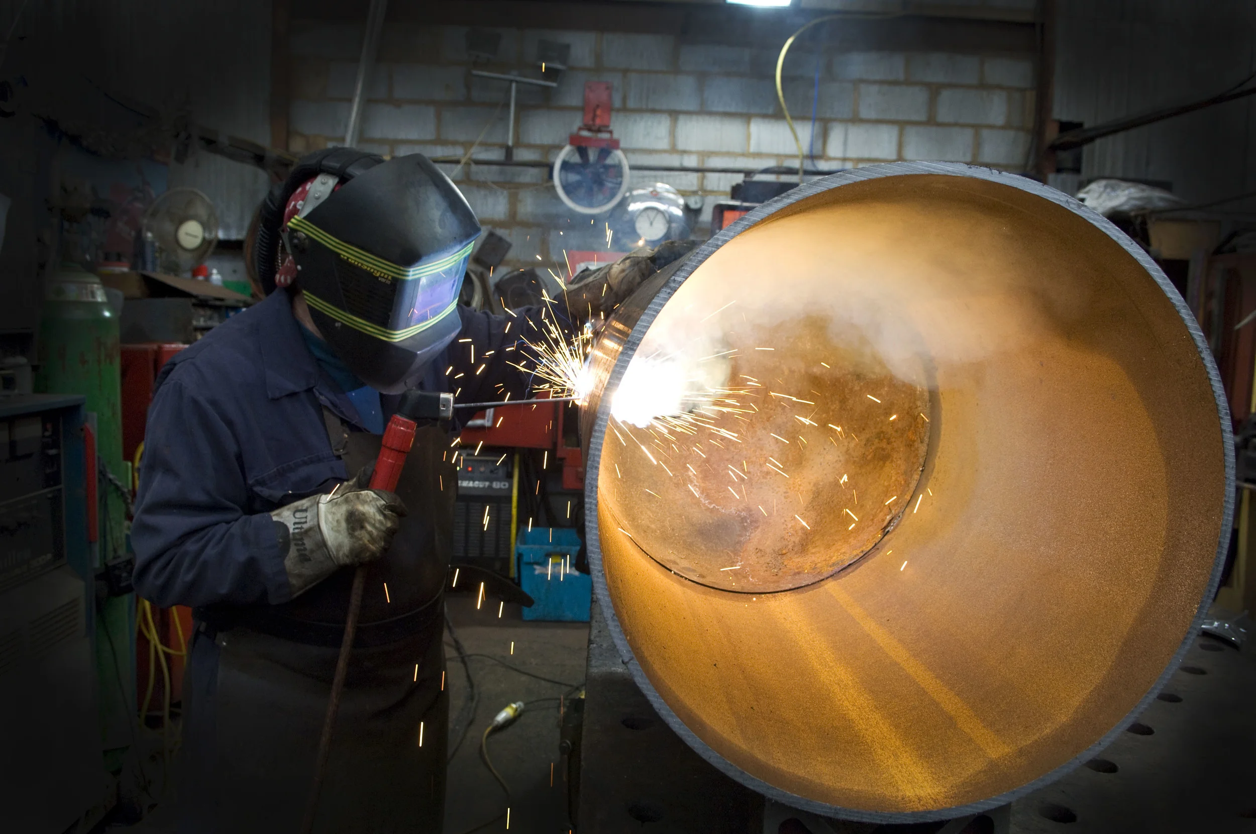 Environmental portrait of a welder at work with moody lighting