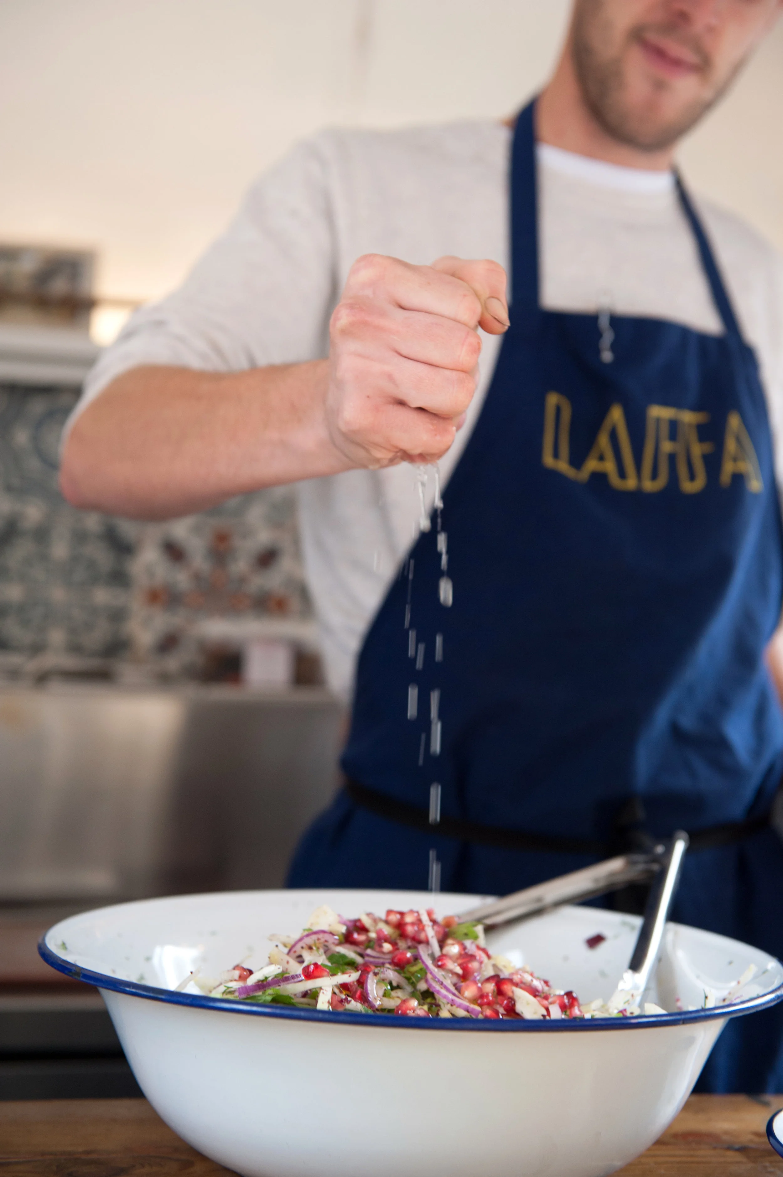 Chef from Laffa Street Food, London, making a salad photograph focus on hand