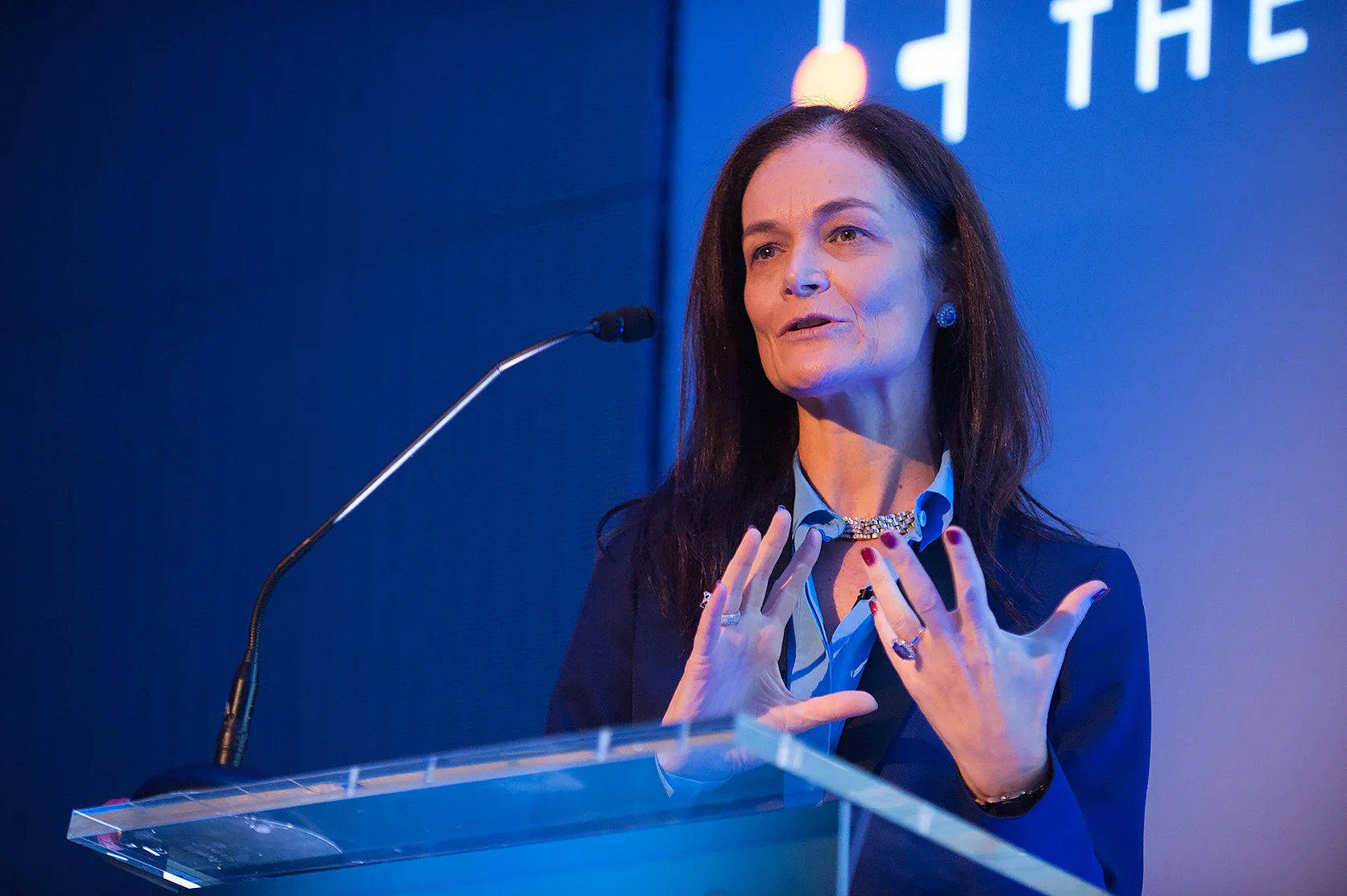 A woman speaking at a podium at a Conference Event in London