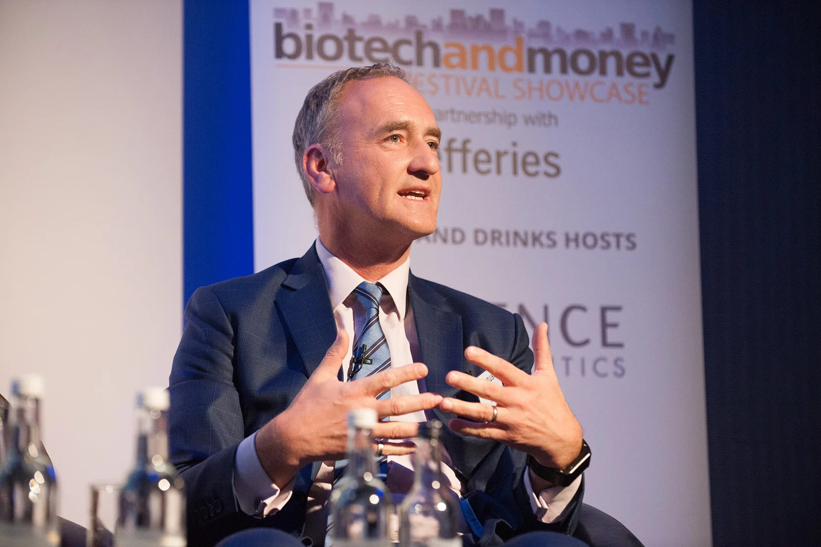 Speaking shot of a man in a suit speaking at a conference event in London