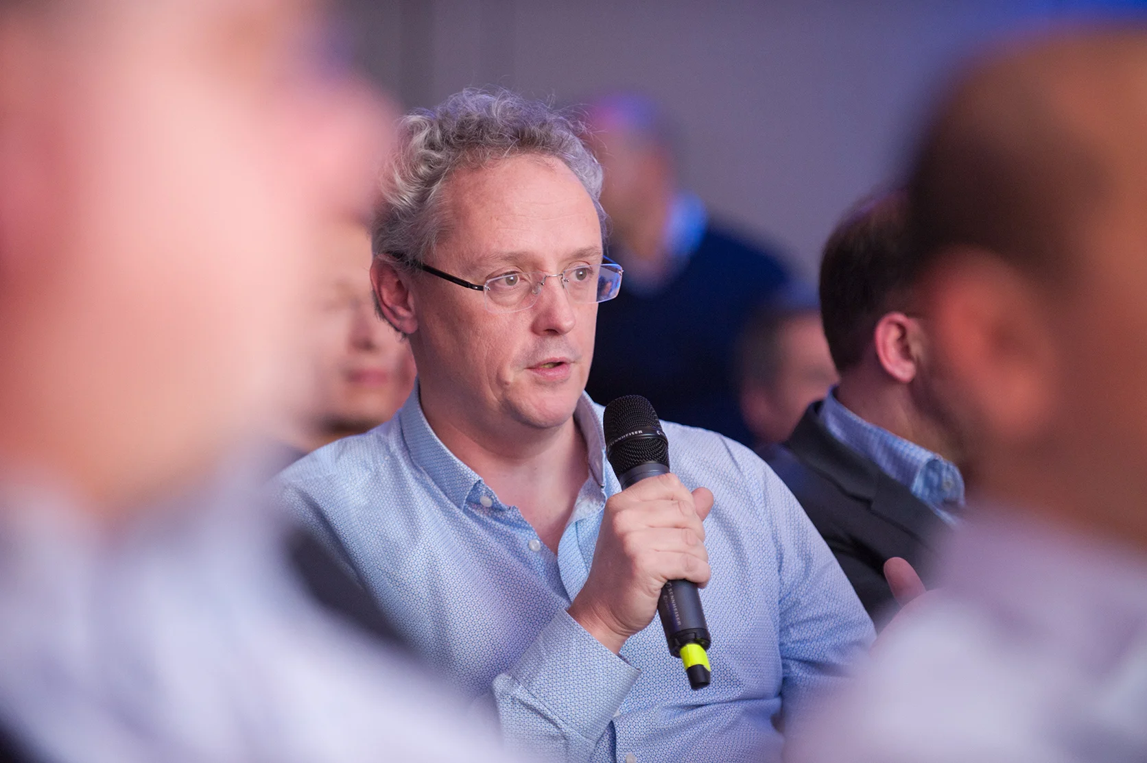 Candid portrait of an attendee speaking during a Q&A at a conference event