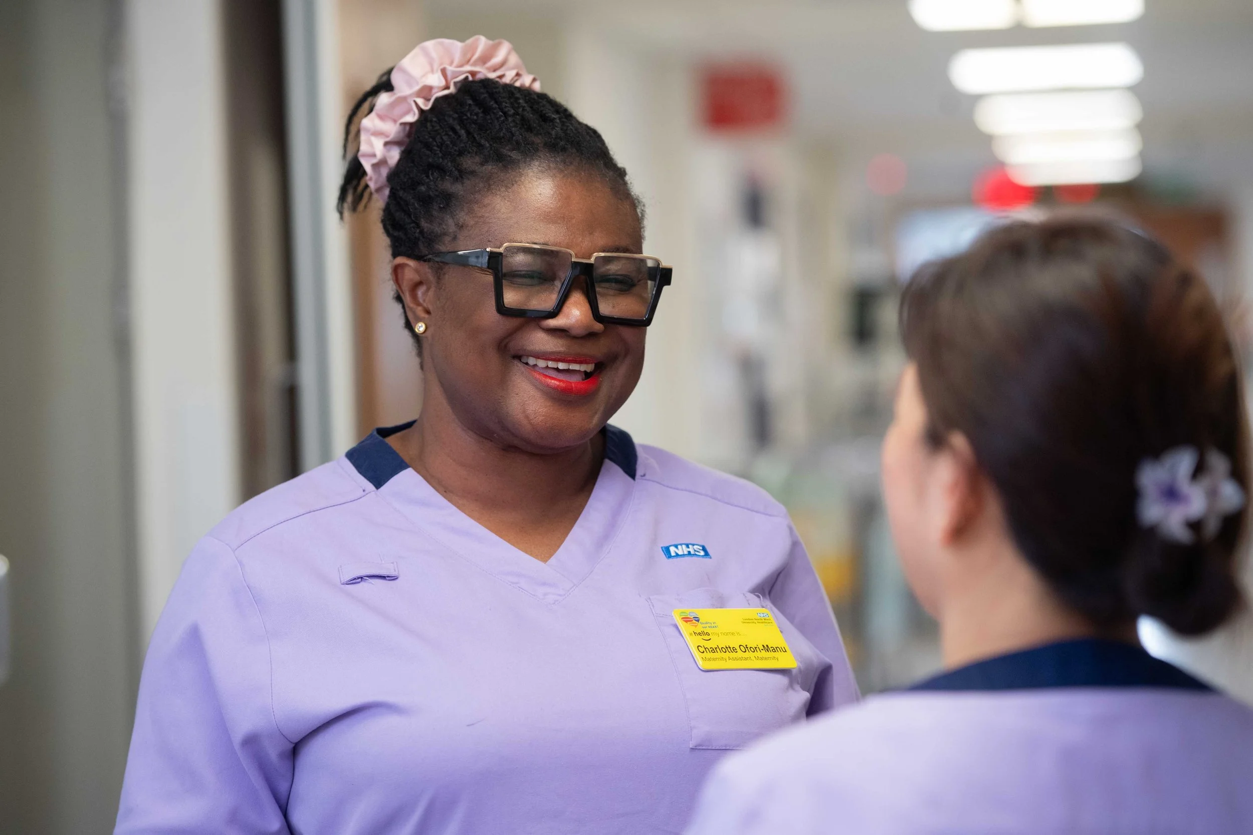 Smiling Nurse Talking with a Colleague in a Hospital
