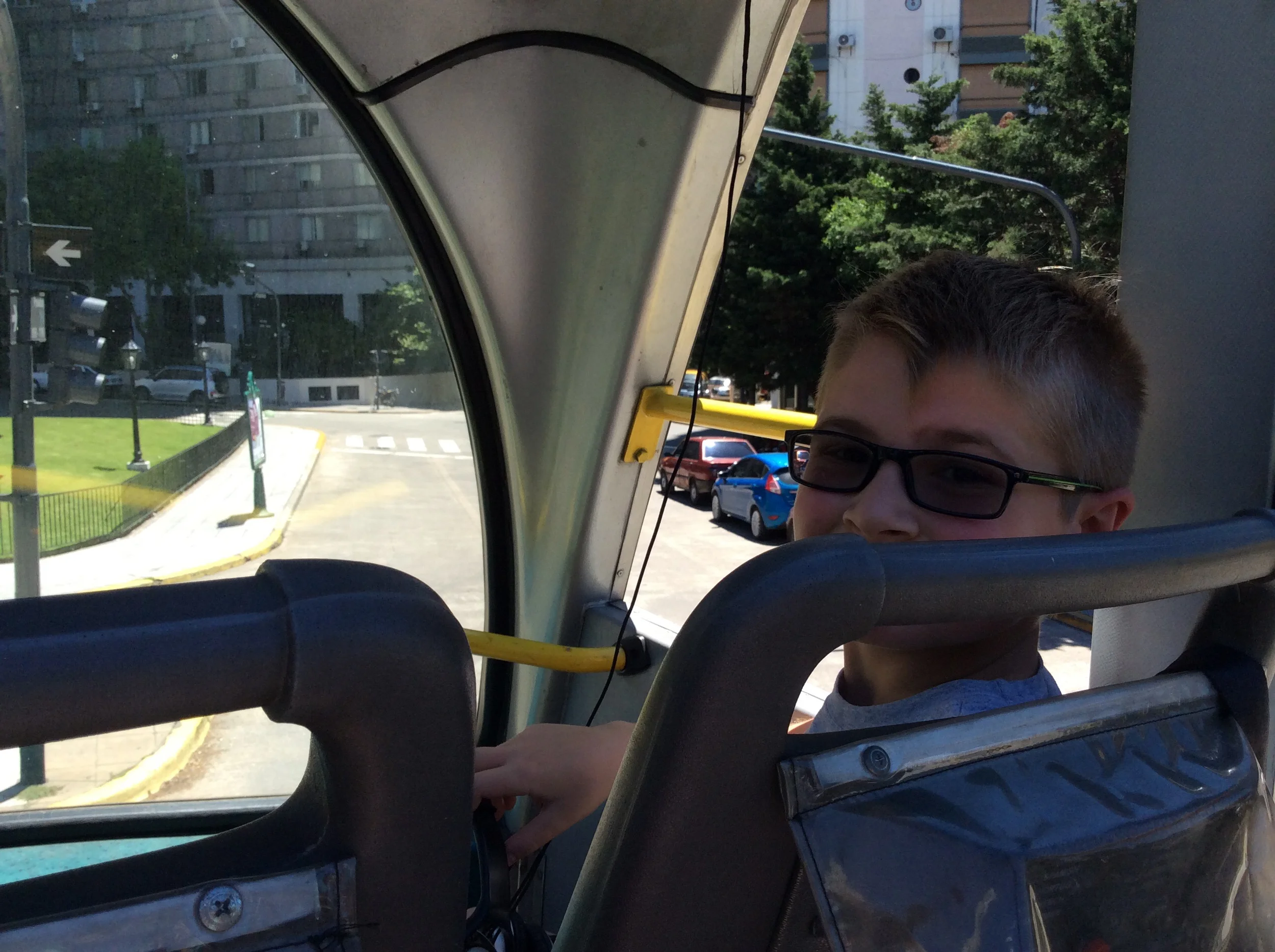 Liam benefiting from some shade in the front seat of the double decker bus. 