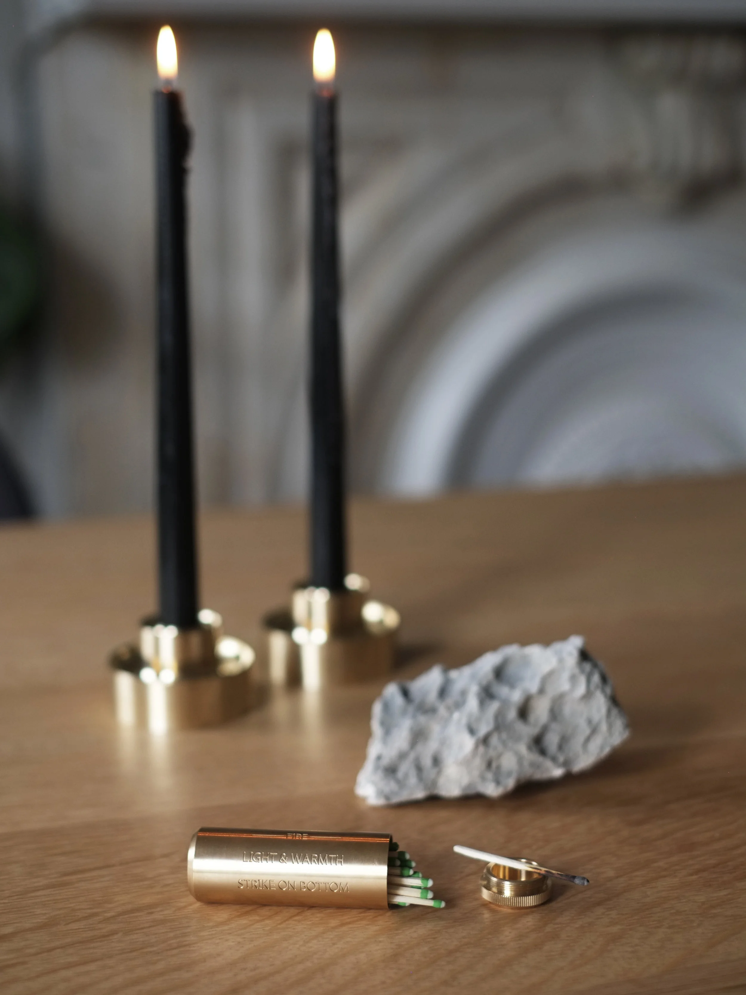 Brass Fire Kit on wooden table next to brass candle holders