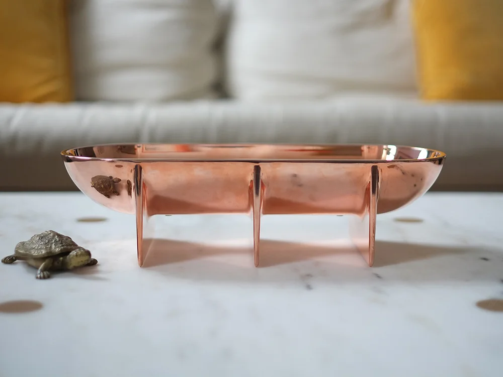 Large Copper Standing Bowl styled on a white marble coffee table